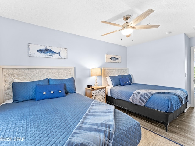 bedroom with ceiling fan, a textured ceiling, and wood finished floors