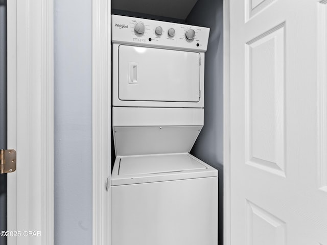 washroom featuring stacked washer and dryer and laundry area