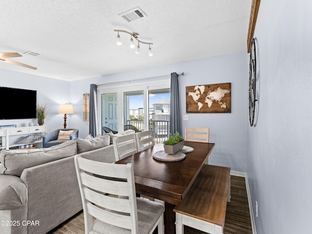 dining space featuring a textured ceiling, ceiling fan, wood finished floors, and visible vents