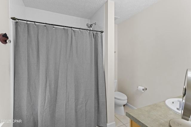 bathroom featuring tile patterned flooring, toilet, a textured ceiling, a shower with shower curtain, and vanity