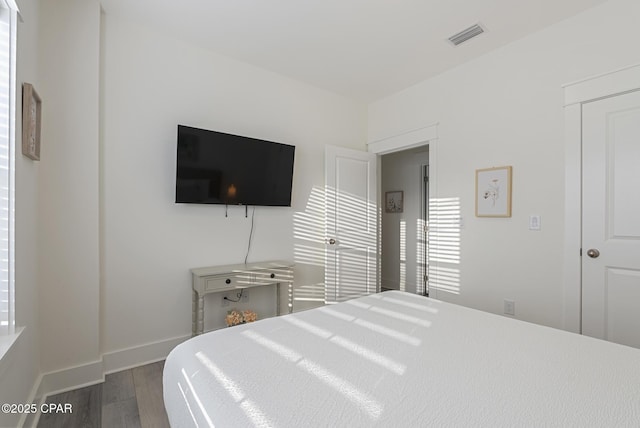 bedroom with dark hardwood / wood-style flooring