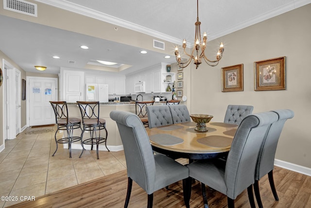 9450 S Thomas Dr Unit 802C, Panama City, FL 32408 - dining area with crown molding, a chandelier, light wood finished floors, recessed lighting, and a tray ceiling