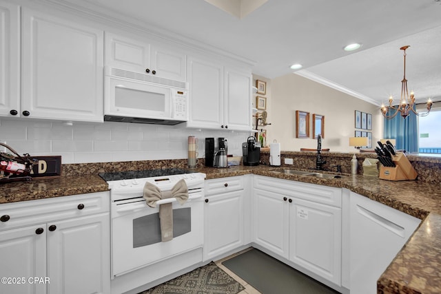 9450 S Thomas Dr Unit 802C, Panama City, FL 32408 - kitchen featuring white appliances, a chandelier, white cabinets, backsplash, and hanging light fixtures