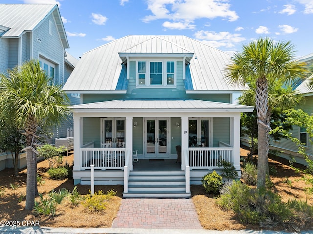 bungalow featuring a porch, french doors, and metal roof