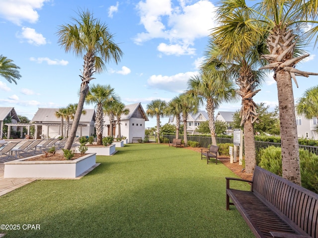view of community featuring a lawn, fence, and a residential view