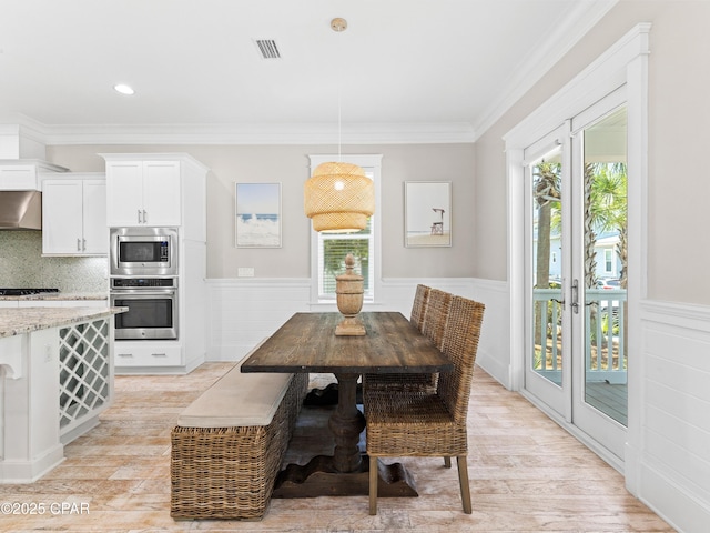 dining space with visible vents, light wood finished floors, and a healthy amount of sunlight