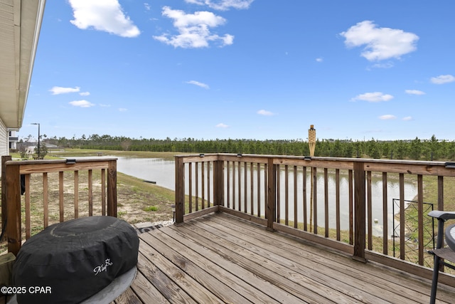 wooden deck with area for grilling and a water view