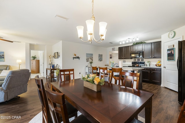 dining area with dark hardwood / wood-style flooring and a chandelier