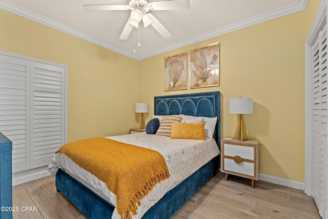 bedroom featuring crown molding, hardwood / wood-style floors, ceiling fan, and a closet