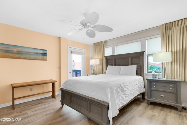 bedroom featuring access to exterior, a ceiling fan, baseboards, and wood finished floors