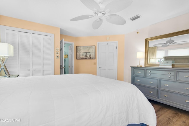 bedroom featuring dark wood-style floors, a closet, visible vents, and a ceiling fan