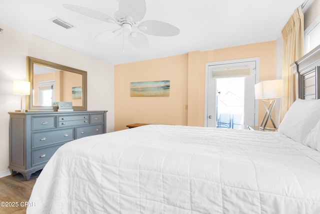 bedroom featuring ceiling fan, wood finished floors, and visible vents