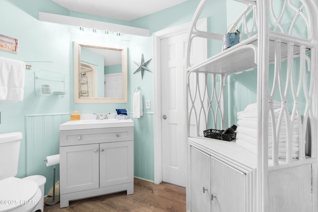 bathroom featuring vanity, toilet, and wood finished floors