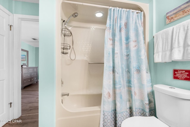 full bathroom featuring visible vents, wood finished floors, shower / bath combo with shower curtain, and toilet