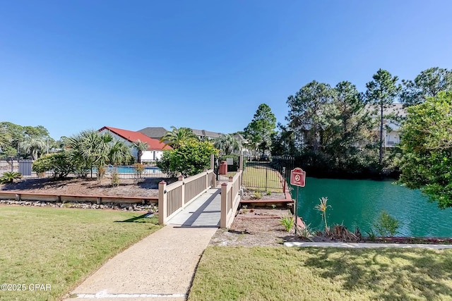 8730 Thomas Dr Unit 1211C, Panama City Beach, FL 32408 - dock area with a lawn, a water view, and fence