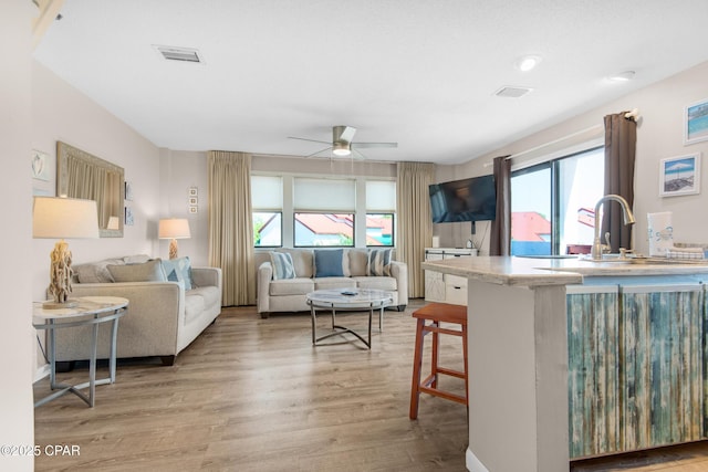 living area featuring plenty of natural light, wood finished floors, and visible vents