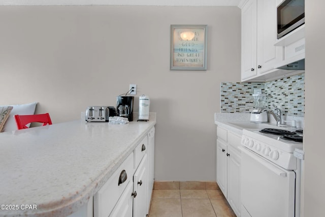 kitchen featuring white cabinetry, light tile patterned floors, decorative backsplash, and white range with electric cooktop