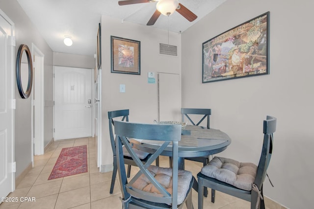 tiled dining space with ceiling fan