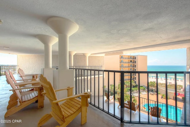 balcony with a water view and a beach view