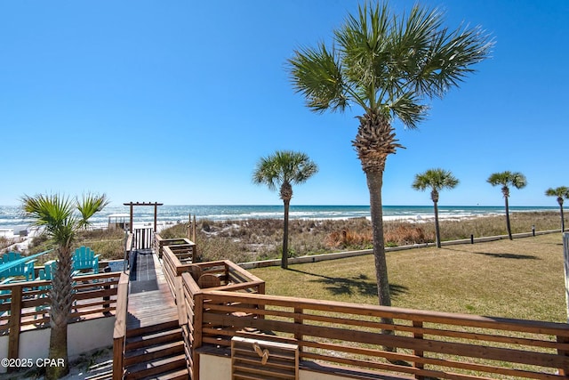 view of jungle gym featuring a lawn, a beach view, and a water view