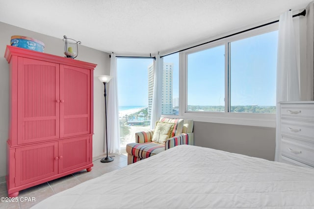 bedroom featuring a textured ceiling, multiple windows, and light tile patterned floors