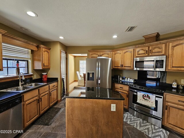 4408 Bylsma Cir, Panama City, FL 32404 - kitchen featuring appliances with stainless steel finishes, a sink, a kitchen island, recessed lighting, and brown cabinets