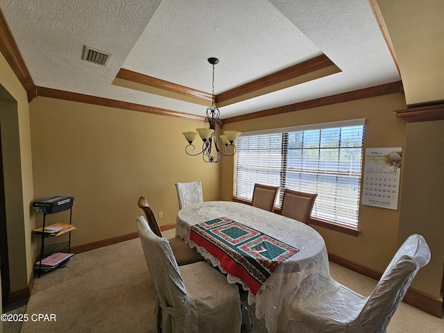 carpeted dining space featuring a raised ceiling, a textured ceiling, a notable chandelier, and ornamental molding