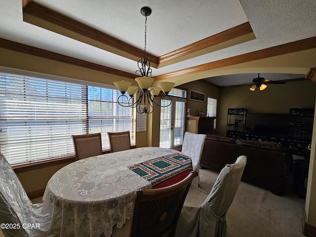 dining room featuring ornamental molding, carpet flooring, and a raised ceiling