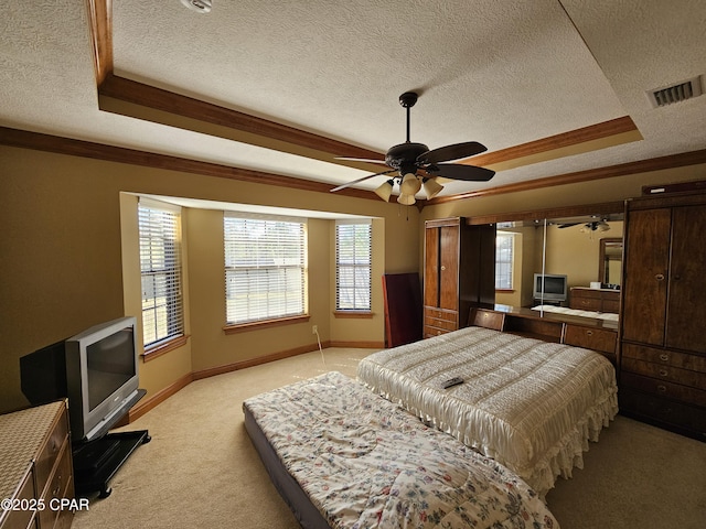 bedroom with a textured ceiling, crown molding, and a raised ceiling