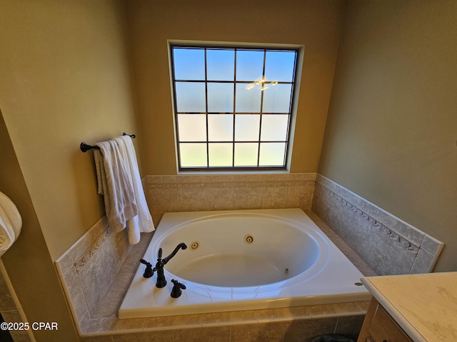 bathroom with tiled tub and vanity