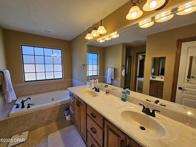 bathroom with tiled bath, vanity, and tile patterned flooring