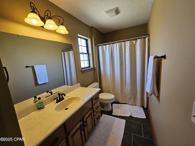 bathroom with a textured ceiling, toilet, vanity, and tile patterned flooring