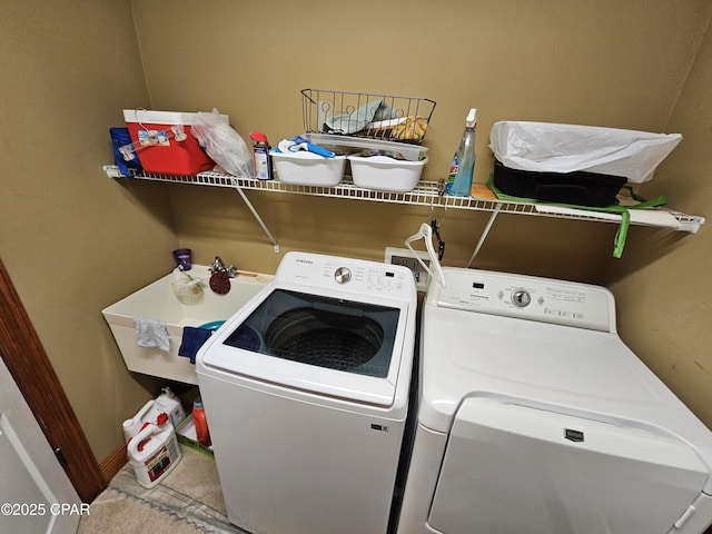 clothes washing area featuring sink and washer and clothes dryer