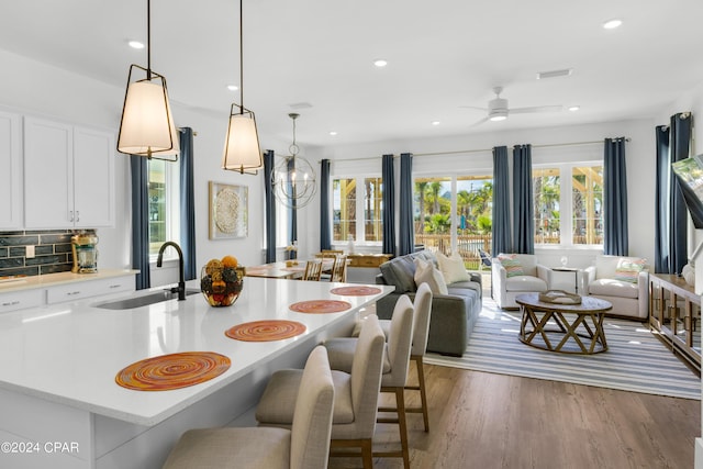 13639 Banana Wind Way, Panama City Beach, FL 32413 - kitchen featuring a sink, open floor plan, light countertops, a kitchen bar, and white cabinets