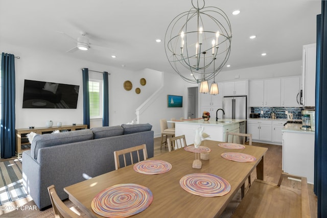 13639 Banana Wind Way, Panama City Beach, FL 32413 - dining room featuring recessed lighting, a ceiling fan, light wood-style flooring, and a chandelier