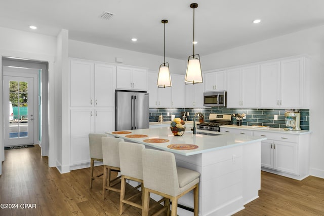 13639 Banana Wind Way, Panama City Beach, FL 32413 - kitchen with appliances with stainless steel finishes, decorative backsplash, light countertops, wood finished floors, and white cabinetry