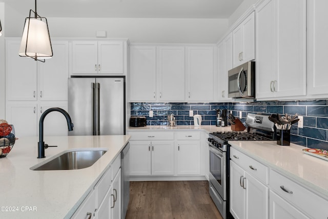 13639 Banana Wind Way, Panama City Beach, FL 32413 - kitchen featuring appliances with stainless steel finishes, a sink, white cabinets, dark wood finished floors, and light stone countertops
