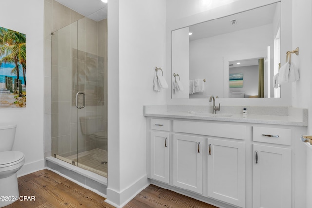 13639 Banana Wind Way, Panama City Beach, FL 32413 - bathroom with toilet, wood finished floors, vanity, a stall shower, and baseboards