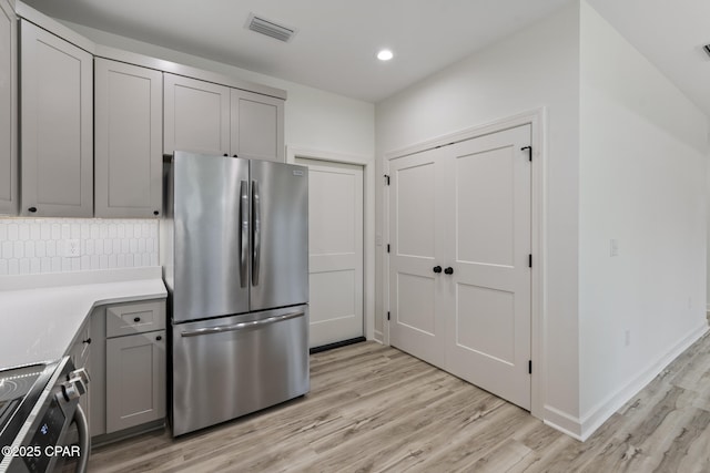 kitchen with visible vents, stainless steel appliances, light countertops, gray cabinetry, and light wood-style floors