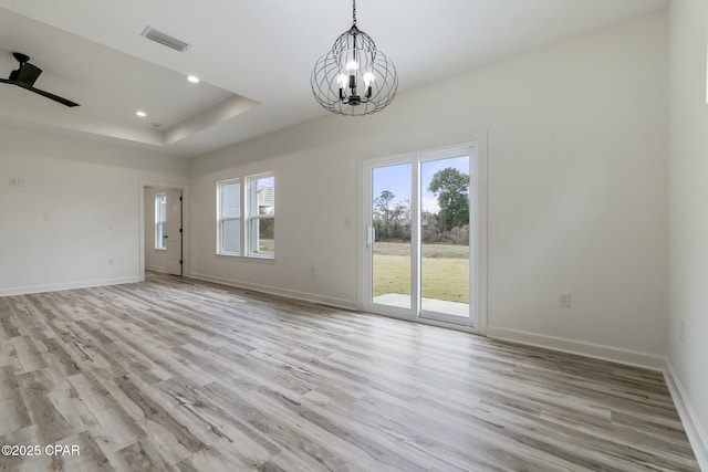 empty room with visible vents, light wood finished floors, and baseboards