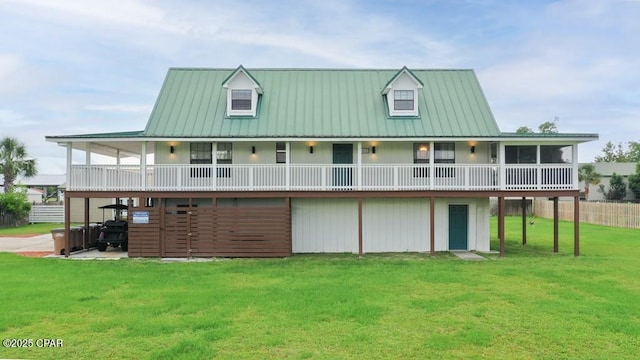 back of house with metal roof, a lawn, and a wooden deck