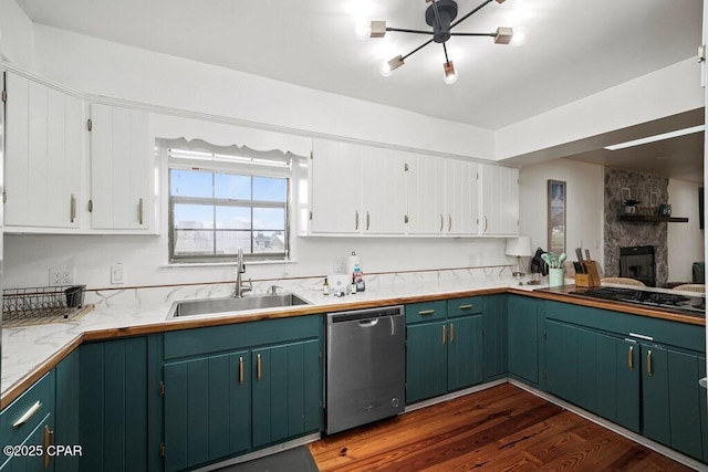 kitchen featuring stainless steel appliances, dark wood-style flooring, a sink, white cabinetry, and light countertops