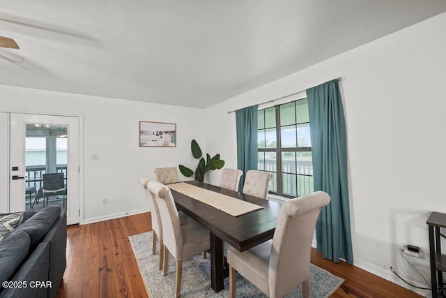 dining area with dark wood-type flooring and baseboards