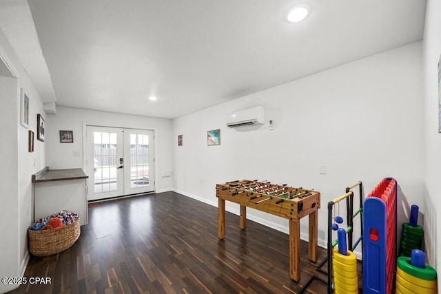 rec room with french doors, a wall unit AC, dark wood-style flooring, recessed lighting, and baseboards