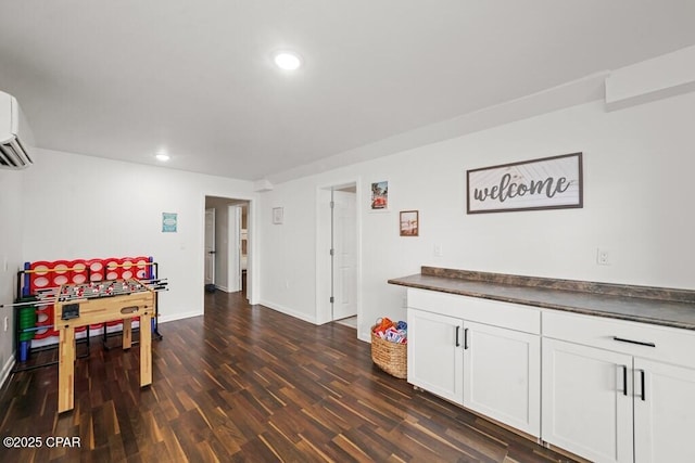 recreation room with baseboards, dark wood-style flooring, and recessed lighting