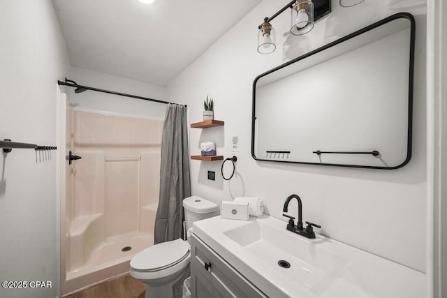 full bath with toilet, a stall shower, wood finished floors, and vanity