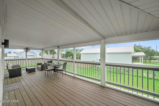 deck with outdoor dining area and a lawn