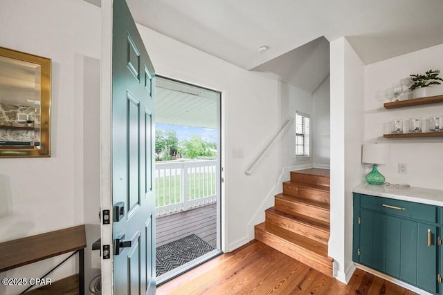 entryway with stairway, wood finished floors, and baseboards