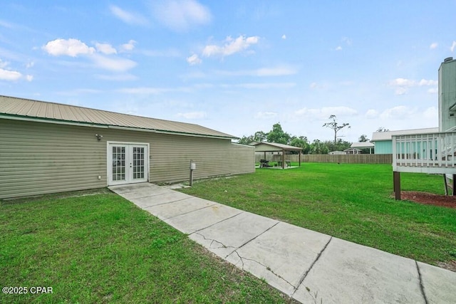 view of yard with french doors and fence