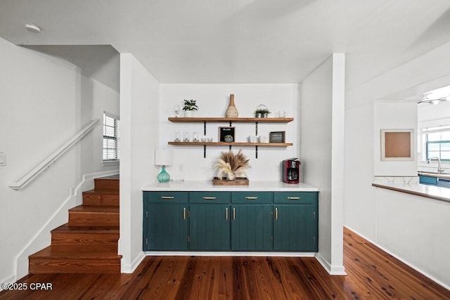 bar featuring a sink, baseboards, stairs, dark wood-style floors, and a dry bar